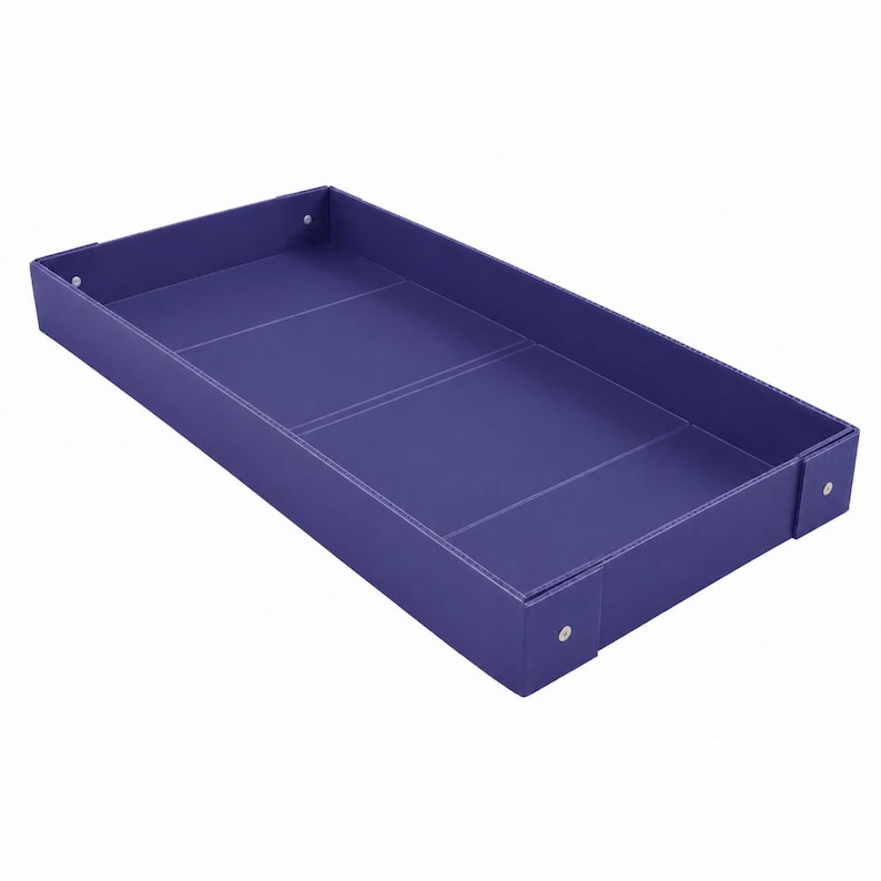 K&ouml;nnte beinhalten: Ein rechteckiges violettes Tablett mit erh&ouml;hten Seiten und einer glatten, flachen Innenfl&auml;che. Das Tablett weist sichtbare wei&szlig;e N&auml;hte entlang der Kanten und Ecken auf, wobei kleine silberfarbene Metallnieten die Ecken der Struktur sichern.
