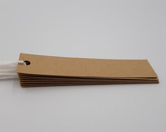 May include: A stack of brown kraft paper gift tags with a hole punched at the top and a white twine string attached.