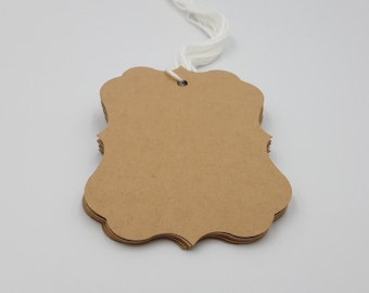 May include: A brown paper gift tag with a scalloped edge and a hole for string. The tag is blank and ready to be written on.