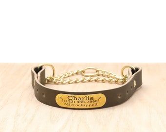 Può includere: Un collare per cani in pelle marrone con catena e finiture color oro. Una targhetta dorata è rivettata al collare e riporta "Charlie" con un numero di telefono e "Microchipped".