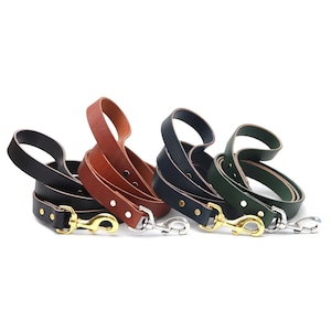 May include: Three leather dog leashes in different colors: brown, dark green, and black. Each leash has a brass hook.