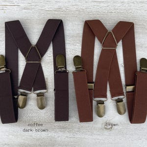 Puede incluir: Dos pares de tirantes, uno marrón oscuro y otro marrón. Ambos pares tienen un diseño clásico con tirantes ajustables y clips metálicos.