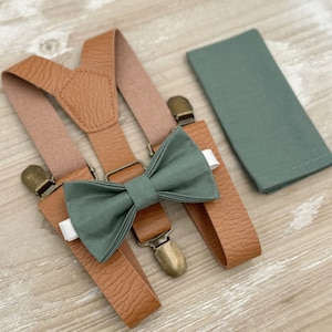 Könnte beinhalten: Ein Set brauner Lederhosenträger mit einer grünen Fliege und einem grünen Einstecktuch.