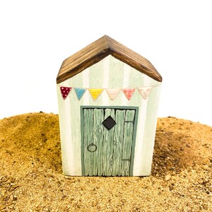 Little wooden beach hut. Miniature seaside beach house. Nautical driftwood style decoration