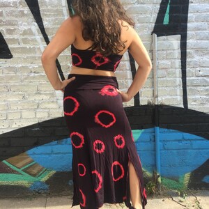 May include: A black and red tie-dye crop top and matching skirt. The skirt has a side slit and a loose, flowing fit.