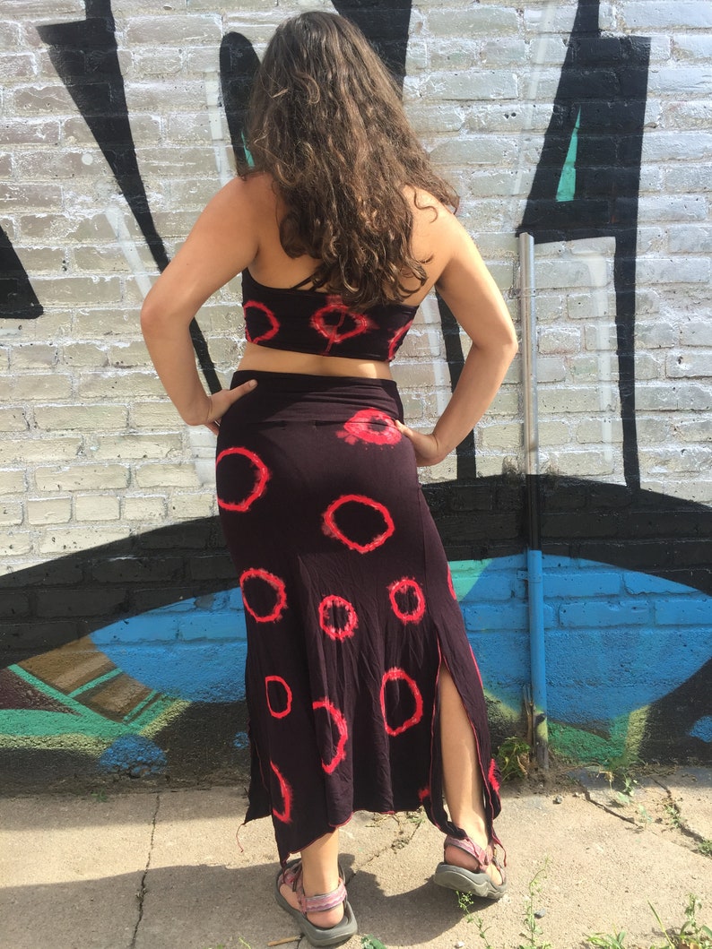 May include: A black and red tie-dye crop top and matching skirt. The skirt has a side slit and a loose, flowing fit.