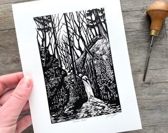 May include: Black and white woodcut print of a waterfall in a forest. The print is titled "Hidden Falls" and signed by the artist.