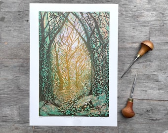 May include: A rectangular art print titled Woodland Awakening featuring a forest path with dark tree trunks, green foliage, and golden light. Two wood carving tools with wooden handles and metal tips are positioned to the right of the print.