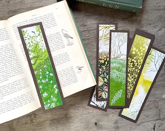 May include: Set of five brown bookmarks with green and yellow nature-themed illustrations. The bookmarks feature a variety of designs, including trees, leaves, and flowers.