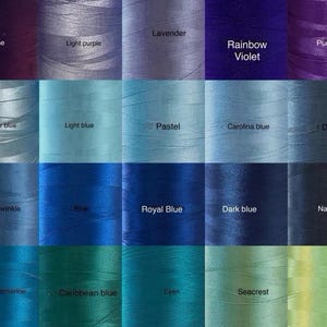 K&ouml;nnte beinhalten: Eine Farbpalette von Garnrollen in verschiedenen Blau-, Lila- und Gr&uuml;nt&ouml;nen. Jede Spule ist mit ihrem Farbnamen beschriftet, darunter "Prune", "Lavender", "Royal Blue" und "Sea foam".