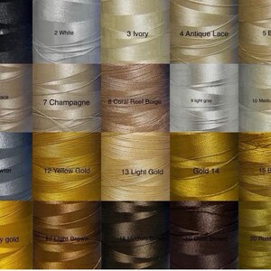 May include: A color chart of spools of thread in various shades. The colors include black, white, ivory, antique lace, beige, old lace, champagne, coral reef beige, light gray, medium grey, pewter, yellow gold, light gold, gold, brass, mary gold, light brown, medium brown, dark brown, and russet brown.