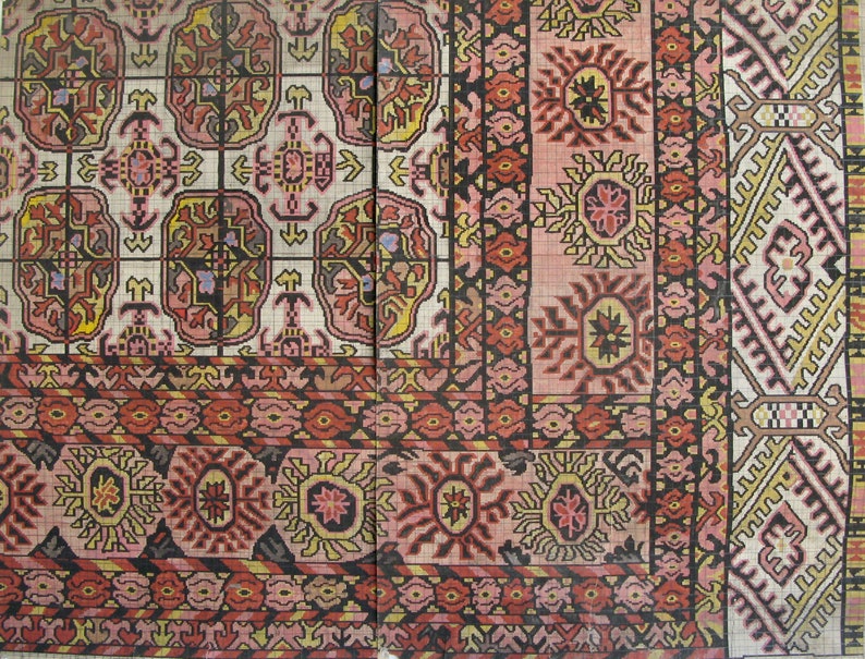 K&ouml;nnte beinhalten: Eine Nahaufnahme eines traditionellen Teppichs mit komplizierten Mustern in Rot-, Rosa-, Gelb- und Schwarzt&ouml;nen. Der Teppich hat ein geometrisches Design mit floralen Motiven.
