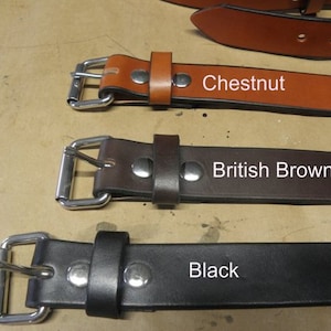 May include: Three leather belts with different colors: chestnut, British brown, and black. Each belt has a silver buckle.