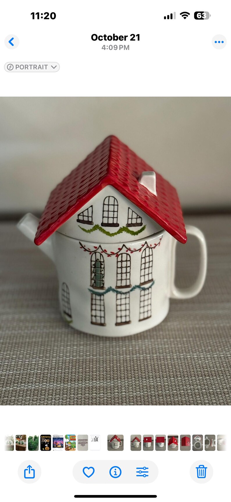 K&ouml;nnte beinhalten: Eine wei&szlig;e Keramik-Teekanne in Form eines Hauses mit rotem Dach. Die Teekanne hat bemalte Fenster und dekorative Girlanden. Henkel und Ausguss sind sichtbar, und das Design hat ein gem&uuml;tliches, festliches Thema.
