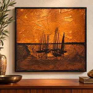 May include: A square wall art piece featuring a textured metallic copper upper section and a dark brown lower section. The artwork depicts the black silhouettes of several sailboats moored in a harbor, all enclosed within a thin black frame.