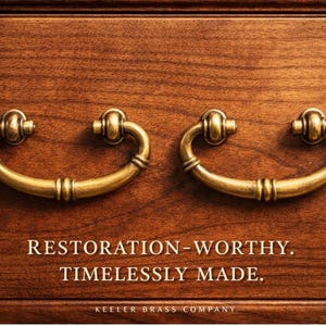 May include: Close-up of two antique brass drawer pulls on a wooden surface. The pulls are curved with decorative detailing. The text reads "RESTORATION-WORTHY. TIMELESSLY MADE."