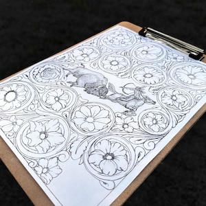 May include: A black and white line drawing of a buffalo and a deer on a white background. The drawing is surrounded by a floral pattern.