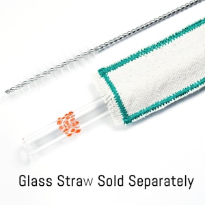 May include: A clear glass straw with orange accents, a white cleaning cloth with green trim, and a silver straw cleaner. The text "Glass Straw Sold Separately" is at the bottom. This set is for cleaning glass straws.