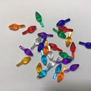 May include: Assortment of colourful plastic Christmas light bulb tips. The tips are in various colours, including red, orange, yellow, green, blue, purple, and clear.