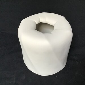 May include: White ceramic vase with a unique, folded design. The vase has a wide opening and a smooth, rounded bottom.