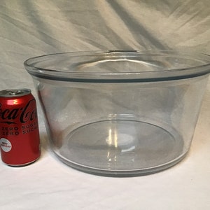 Könnte beinhalten: Eine große, durchsichtige Glasschüssel mit einem grauen Rand. Die Schüssel ist leer und steht auf einer weißen Oberfläche. Eine Dose Coca-Cola Zero Sugar steht neben der Schüssel zur Größenbestimmung.