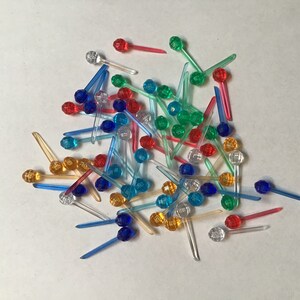 Peut inclure: Un tas d'ampoules de Noël colorées avec des tiges en plastique transparent. Les ampoules sont rouges, bleues, vertes et orange.