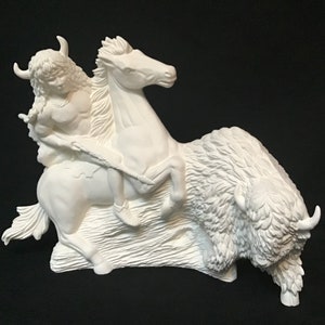 Puede incluir: Una escultura de cerámica blanca de un guerrero nativo americano montando un caballo y lanzando una lanza a un búfalo. La escultura está detallada con características y texturas realistas.