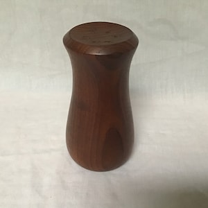 Może przedstawiać: Brązowy drewniany wazon z zaokrągloną podstawą i lekko rozszerzającym się wierzchołkiem.