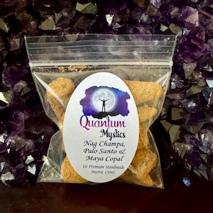 May include: A clear plastic bag containing 10 brown incense cones. The bag has a white label with the text "Quantum Mystics" and "Nag Champa, Palo Santo & Maya Copal" and "10 Premium Handmade Incense Cones".