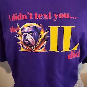 Puede incluir: Camiseta morada con un gráfico amarillo y dorado de un bulldog con el texto "No te escribí... lo hizo OIL".
