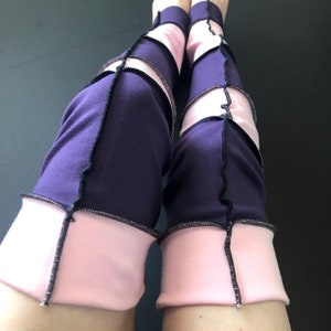Könnte beinhalten: Lila und rosa Leggings mit schwarzen Nähten. Die Leggings sind aus einem dehnbaren Stoff und haben ein einzigartiges Patchwork-Design.