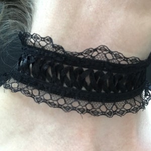May include: A black lace choker with a delicate, intricate design. The choker is made of a soft, stretchy material and has a ruffled edge.