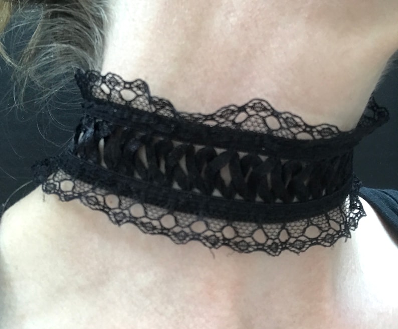 May include: A black lace choker with a delicate, intricate design. The choker is made of a soft, stretchy material and has a ruffled edge.