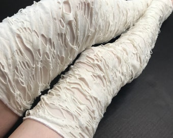 May include: White ripped thigh-high stockings with a distressed, shredded look. The stockings are made of a soft, stretchy fabric and have a comfortable fit.