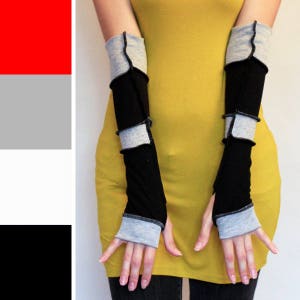 May include: A pair of black and gray fingerless gloves with a yellow shirt in the background.