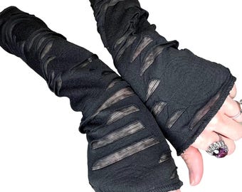 May include: A pair of black fingerless gloves with a distressed, mesh-like design. The gloves are made of a soft, stretchy fabric and have a loose fit.