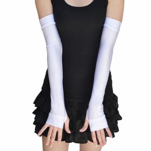 May include: A pair of white long fingerless gloves made of a silky material. The gloves extend to the elbow.