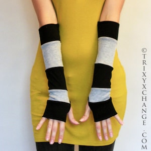 Puede incluir: Un par de guantes sin dedos de rayas negras y grises. Los guantes están hechos de un tejido suave y elástico y tienen un ajuste cómodo.