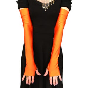 May include: A pair of long orange fingerless gloves made of a shiny, stretchy fabric. The gloves extend to the elbow.