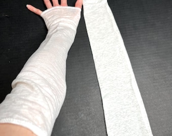 May include: A pair of long, white, lightweight arm sleeves made from a thin, semi-sheer fabric. One sleeve is worn on an arm, extending from the knuckles to the upper forearm, while the second sleeve lies flat beside it, showing a consistent texture.