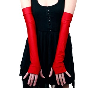 K&ouml;nnte beinhalten: Ein Paar lange, rote Satinhandschuhe. Die Handschuhe reichen bis zum Ellbogen und haben ein eng anliegendes, dehnbares Design.