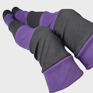 May include: Leggings with a striped design in purple and grey. The leggings have alternating bands of solid grey and purple fabric. The cuffs and top of the leggings are solid purple.