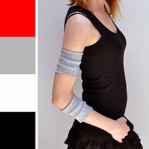May include: A gray elbow sleeve with a black tank top and a black skirt.