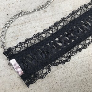 May include: Black lace choker necklace with a silver chain and a metal clasp.