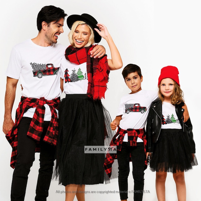 May include: A family of four wearing matching white t-shirts with a red truck carrying a Christmas tree design. The adults are wearing red and black plaid shirts and the children are wearing black pants and a black leather jacket. The text "FAMILYSTA" is visible in the image.