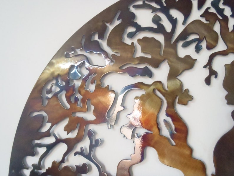 Op de afbeelding: Een metalen wandsculptuur in de vorm van een boom met een bruine, gouden en blauwe iriserende afwerking.