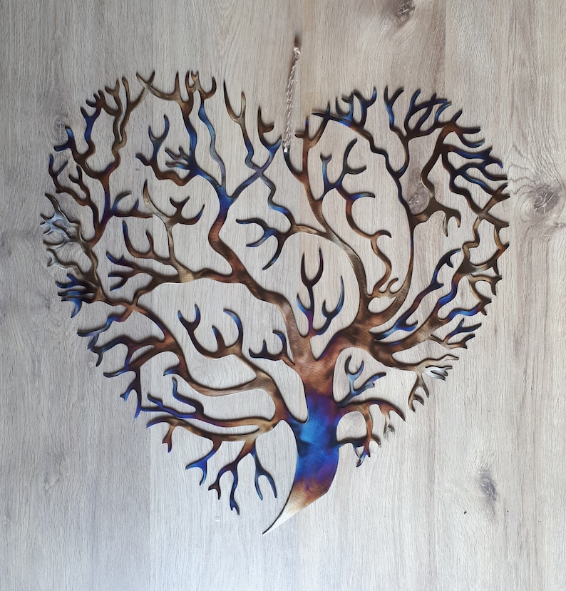 K&ouml;nnte beinhalten: Ein herzf&ouml;rmiger Wandbehang aus Metall in Form eines Baumes mit einem Farbverlauf von Blau, Lila und Braun. Der Baum hat viele &Auml;ste und ist aufwendig gestaltet.