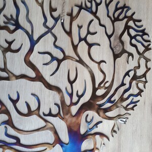 K&ouml;nnte beinhalten: Eine Wandskulptur aus Metall, die einen Baum mit einem blauen und braunen Farbverlauf darstellt. Der Baum hat viele &Auml;ste und hat die Form eines Herzens.
