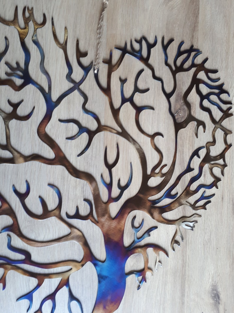 K&ouml;nnte beinhalten: Eine Wandskulptur aus Metall, die einen Baum mit einem blauen und braunen Farbverlauf darstellt. Der Baum hat viele &Auml;ste und hat die Form eines Herzens.