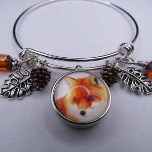 May include: Silver charm bracelet with a fox charm, two acorn charms, two leaf charms, and two amber glass beads.